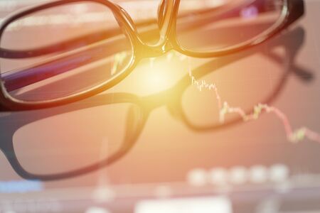 financial chart stock trading seen by unfocused glasses background