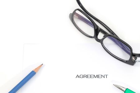 Sign on contract document with fountain pen and glasses on white backgroundの写真素材