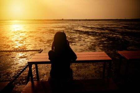 Women sitting and watching the sea at sunset nature background