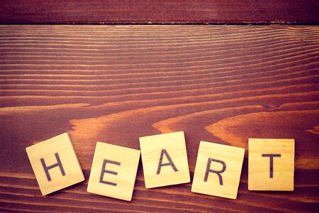 Alphabet heart on old vintage wood backgroundの写真素材