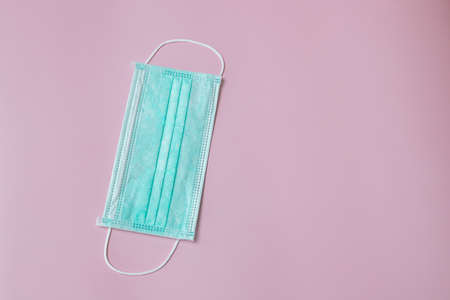 Face mask to help prevent infection from Covid-19 on pink background