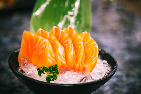 Salmon sashimi is often the first course in a formal Japanese meal over marble black backgroundの写真素材