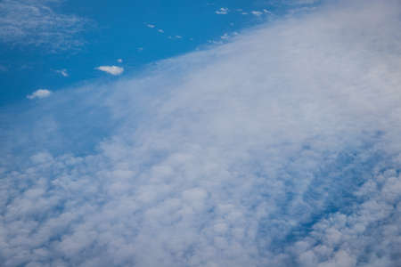 Capturing the fluffy white clouds and the blue sky View from planeの写真素材