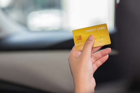 Driver paying with credit card isolated on car backgroundの写真素材