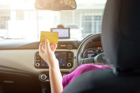 Driver paying with credit card isolated on car backgroundの写真素材