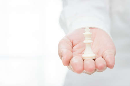 businessman devised his strategy from the king on the white table backgroundの写真素材