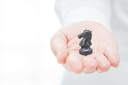 businessman plans his strategy from the horse of the chess hand backgroundの写真素材