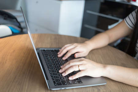 Working from home on laptop while typing chat to customer communicates on internet in home office, Concept of remote work e-learning business from homeの写真素材