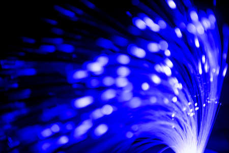 Close up of blurred light fiber optics for communication technology network on black backgroundの写真素材