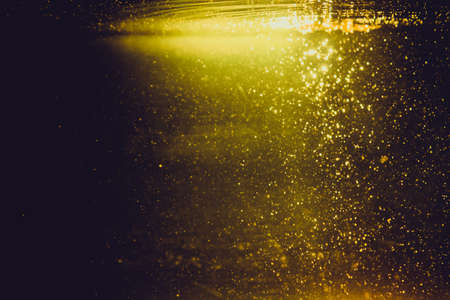 Golden bokeh of lights on black backgroundの写真素材