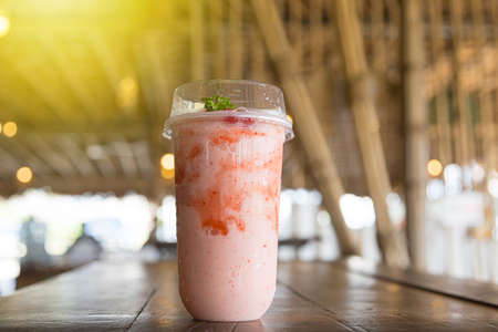 Strawberry smoothie or milkshake in a clear glass mint decoration on wooden table Healthy breakfast and snacks in the cafeの写真素材