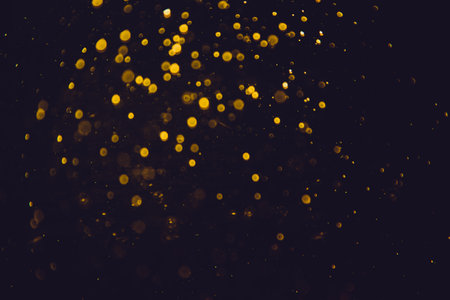 Vintage gold bokeh created by neon lights with black backgroundの写真素材
