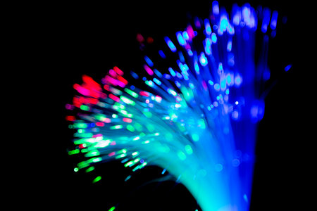 Close up of blurred light fiber optics for communication technology network on black backgroundの写真素材