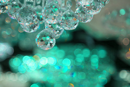 Beautiful crystal chandeliers warm light Light reflecting through brushed czech glass crystals hanging on vintage chandelier with bokeh backgroundの写真素材