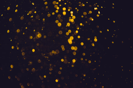 Vintage gold bokeh created by neon lights with black backgroundの写真素材
