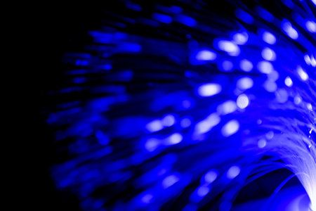 Close up of blurred light fiber optics for communication technology network on black backgroundの写真素材