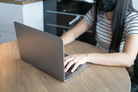 Working from home on laptop while typing chat to customer communicates on internet in home office, Concept of remote work e-learning business from homeの写真素材