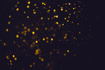 Vintage gold bokeh created by neon lights with black backgroundの写真素材