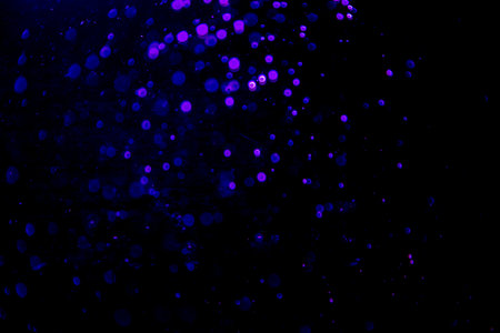 Abstract blue bokeh of water with black backgroundの写真素材