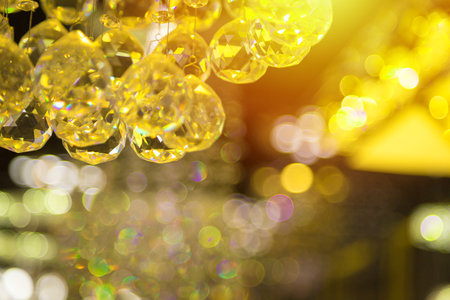 Beautiful crystal chandeliers warm light reflecting through brushed czech glass crystals hanging on vintage chandelier with bokeh backgroundの写真素材