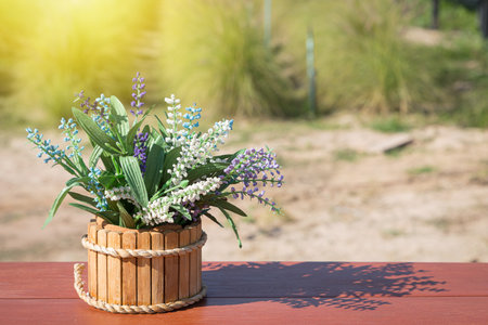 Beautiful flowers basket on wood table in the flower gardenの写真素材
