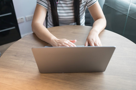 Working from home on laptop while typing chat to customer communicates on internet in home office, Concept of remote work e-learning business from homeの写真素材
