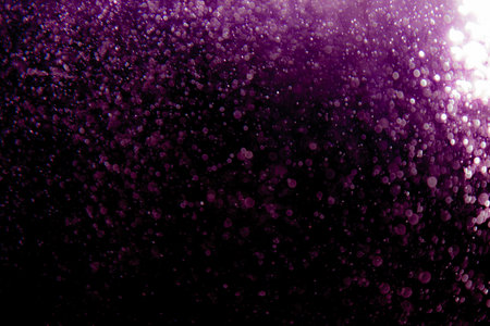 Purple bokeh texture on black backgroundの写真素材