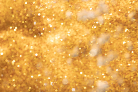 Golden abstract sparkles or glitter lights Defocused circles bokeh backgroundの写真素材