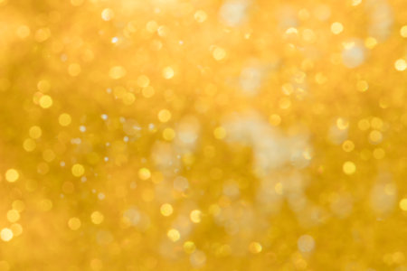 Golden abstract sparkles or glitter lights Defocused circles bokeh backgroundの写真素材