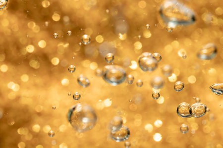Golden abstract sparkles or glitter lights Defocused circles bokeh backgroundの写真素材
