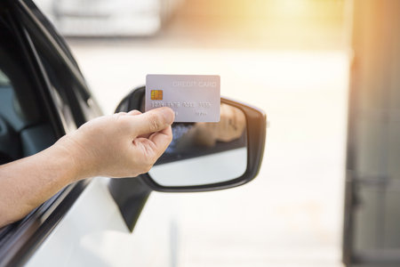 Closed up hand use credit card on car to pay for fuel, Credit card for financial transactionsの写真素材