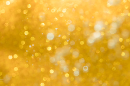 Golden abstract sparkles or glitter lights Defocused circles bokeh backgroundの写真素材