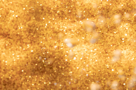 Golden abstract sparkles or glitter lights Defocused circles bokeh backgroundの写真素材