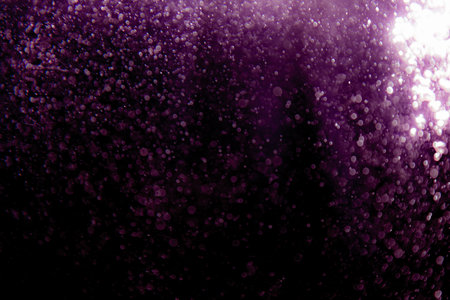 Purple bokeh texture on black backgroundの写真素材