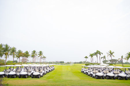 Golf cart in fairway of golf course with green grass field nature backgroundの写真素材