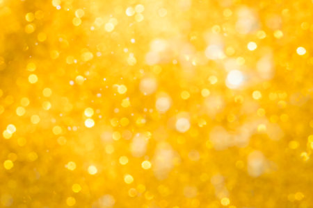 Golden abstract sparkles or glitter lights Defocused circles bokeh backgroundの写真素材