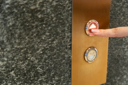 finger woman presses the elevator button up and down button.