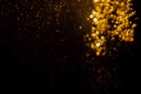 Blurred photo with golden dots visible glittering, shining brightly look and feel luxurious Suitable for use as a wallpaper showing luxury and taste.の写真素材