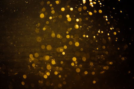 Blurred photo with golden dots visible glittering, shining brightly look and feel luxurious Suitable for use as a wallpaper showing luxury and taste.の写真素材