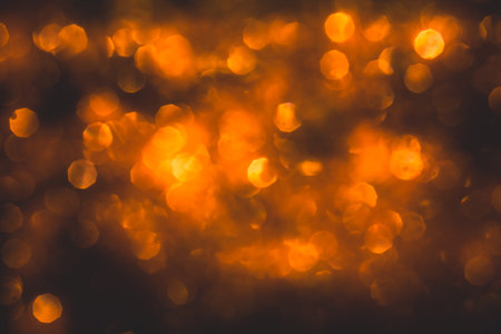 Bokeh from blurred orange flame on black backgroundの写真素材