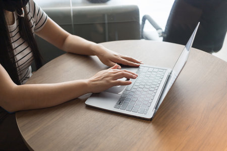 Working from home on laptop while typing chat to customer communicates on internet in home office, Concept of remote work e-learning business from homeの写真素材