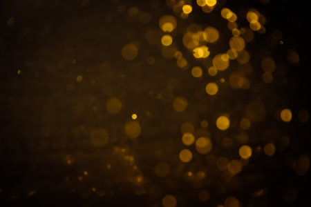 Blurred photo with golden dots visible glittering, shining brightly look and feel luxurious Suitable for use as a wallpaper showing luxury and taste.の写真素材