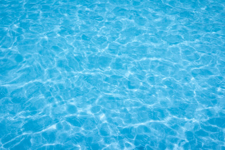 The light reflects blue in the water in the swimming pool. It looks fresh and lively, suitable for use as a wallpaper backgroundの写真素材
