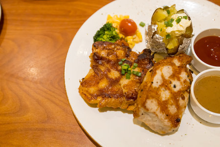 Grilled pork steak served with mashed potatoes and vegetablesの写真素材