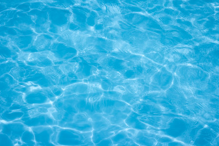 The light reflects blue in the water in the swimming pool. It looks fresh and lively, suitable for use as a wallpaper backgroundの写真素材