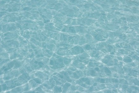 The light reflects blue in the water in the swimming pool. It looks fresh and lively, suitable for use as a wallpaper backgroundの写真素材
