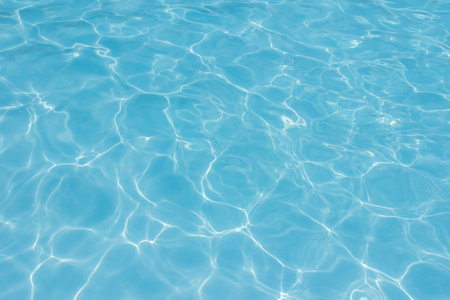 The light reflects blue in the water in the swimming pool. It looks fresh and lively, suitable for use as a wallpaper backgroundの写真素材