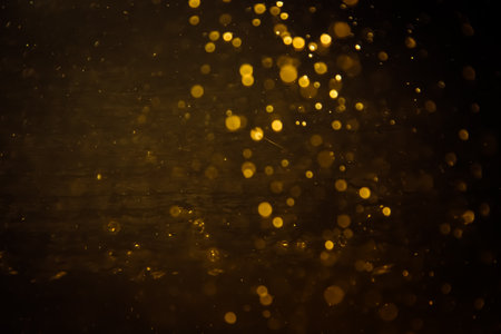 Blurred photo with golden dots visible glittering, shining brightly look and feel luxurious Suitable for use as a wallpaper showing luxury and taste.の写真素材