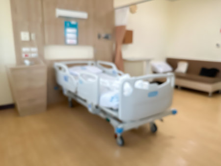 Blur image of Hospital bed in a luxurious and modern patient room. The atmosphere is clear and you can see the surrounding view. There are windows around the room.の写真素材