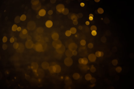 Blurred photo with golden dots visible glittering, shining brightly look and feel luxurious Suitable for use as a wallpaper showing luxury and taste.の写真素材